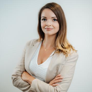 BEAUTY SOLUTIONS Team | Sales Area Manager | Cornelia Sientschnig | © BEAUTY SOLUTIONS | Martin Hofmann Fotografie Ein professionelles Porträtfoto einer lächelnden Frau in eleganter Kleidung. Sie hat die Arme verschränkt und steht vor einem neutralen Hintergrund. Das Bild vermittelt einen Eindruck von Selbstbewusstsein und Professionalität.